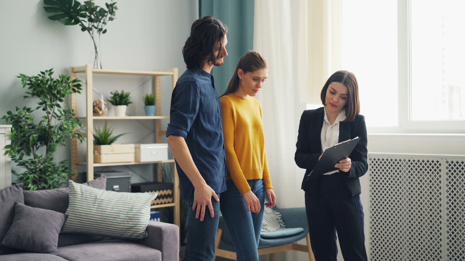 Ein Paar steht im Wohnzimmer der Immobilie, die es verkaufen will